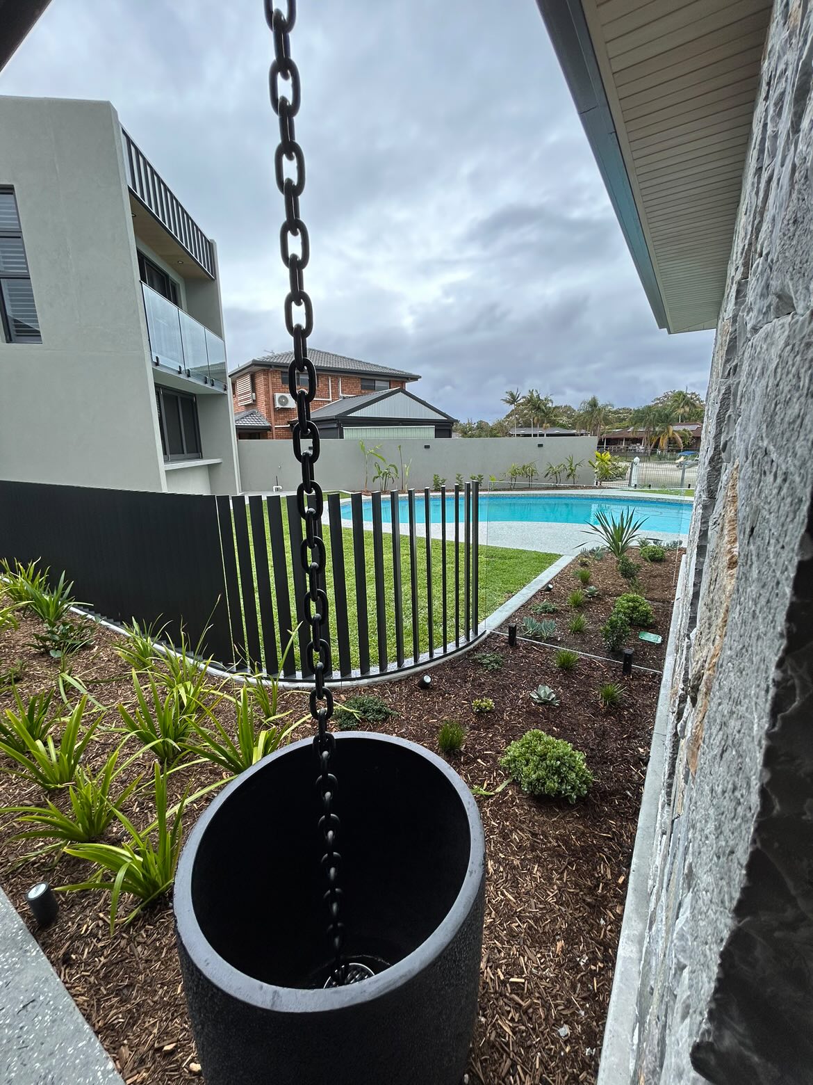 Monument curved pool fence with landscaping